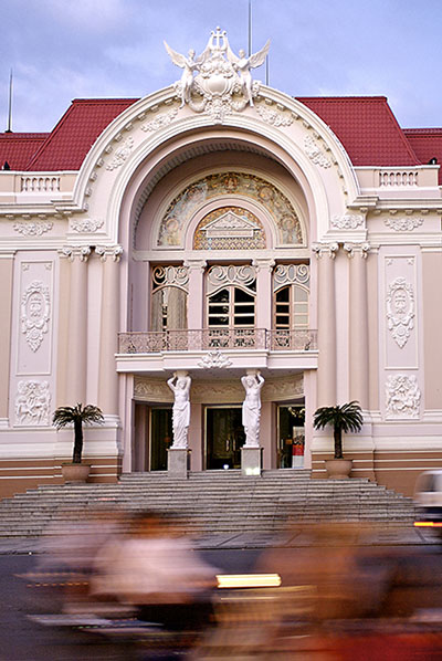 A blur of traffic passing the elegantly preserved facade of Saigon's municipal theatre