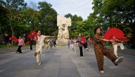 The colourful sight of a group of women performing Tai Chi exercises with red fans in an Old Quarter park in Hanoi
